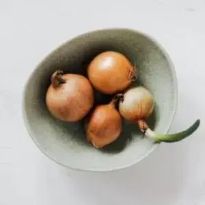bowl of onions with one sprouting