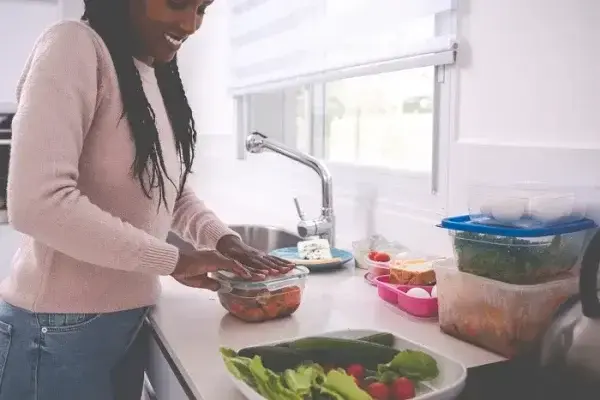 person placing food into freezer containers