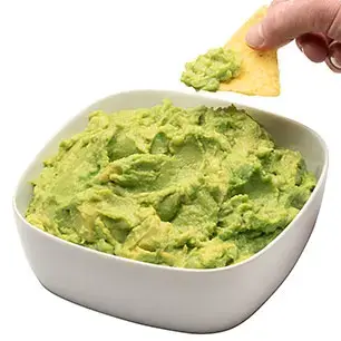 Hand Dipping Chip into Chunky Avocado Pulp