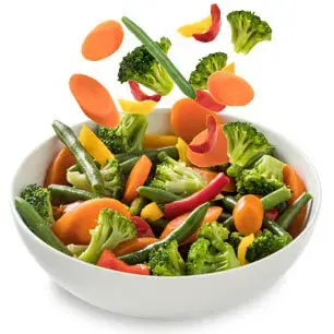 vegetables dropping into bowl